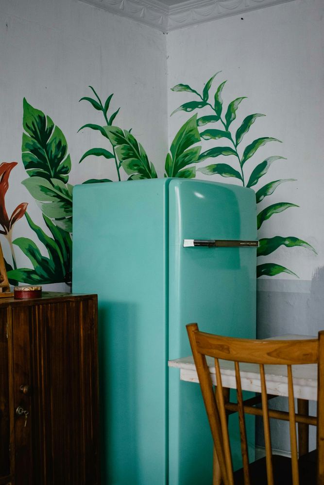 Frigorifero dal design rétro color menta in una cucina con piante